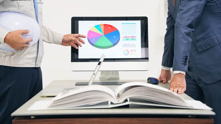 Beratungsgespräch vor Monitor und Planungsbuch