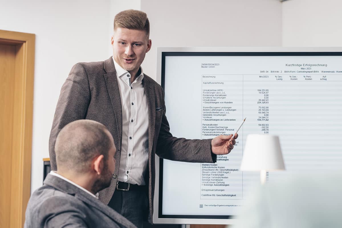 Beratung im Team vor großem Bildschirm